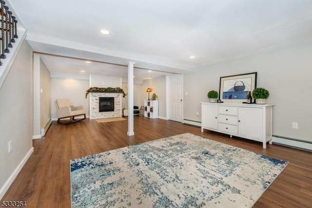 interior space with baseboard heating, dark hardwood / wood-style flooring, and ornate columns