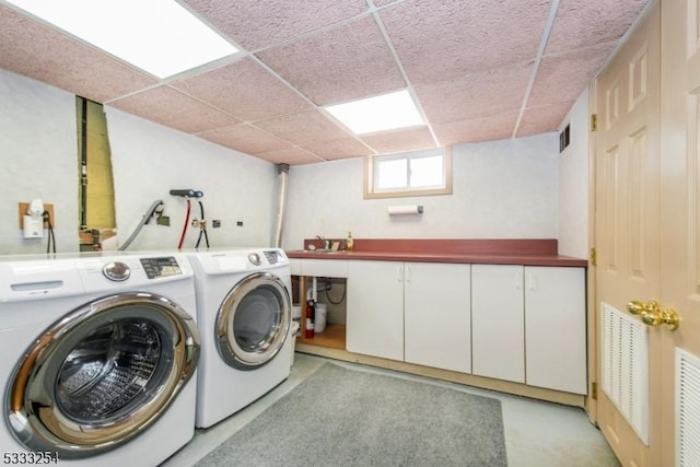 laundry room featuring cabinets and washing machine and clothes dryer