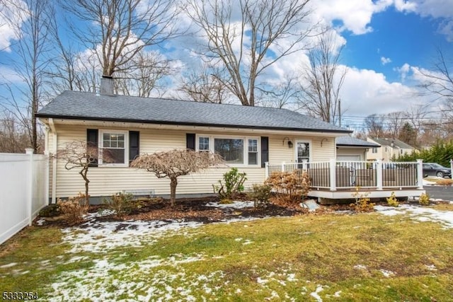 ranch-style house featuring a front lawn and a deck