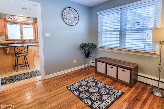 sitting room with dark wood-type flooring and baseboard heating