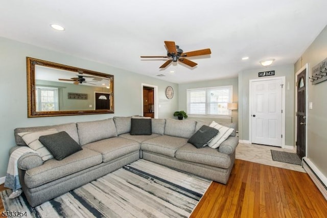 living room with ceiling fan, a baseboard radiator, and light hardwood / wood-style floors