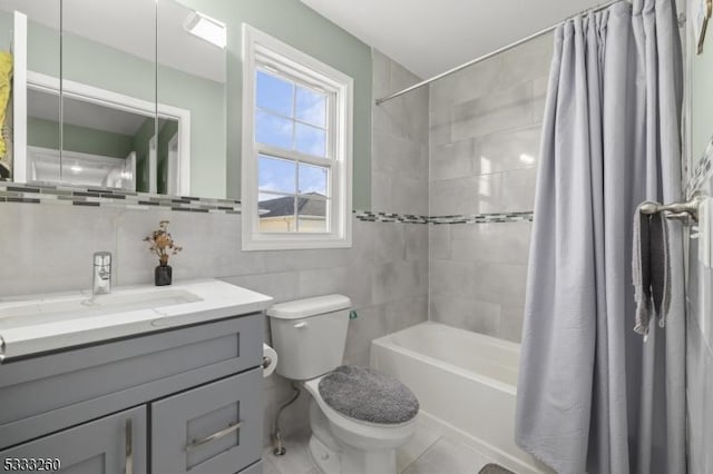 full bathroom featuring toilet, tile walls, tile patterned floors, shower / tub combo, and vanity