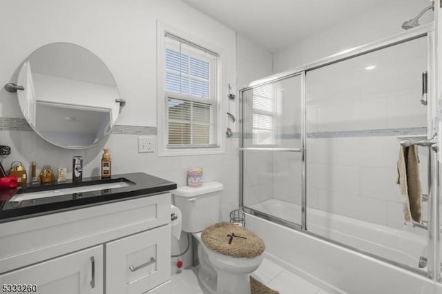 full bathroom with toilet, vanity, tile patterned floors, and enclosed tub / shower combo