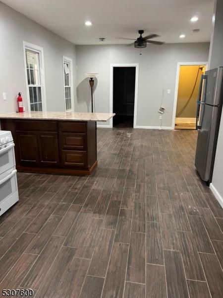 kitchen with ceiling fan, white stove, dark brown cabinets, and stainless steel refrigerator