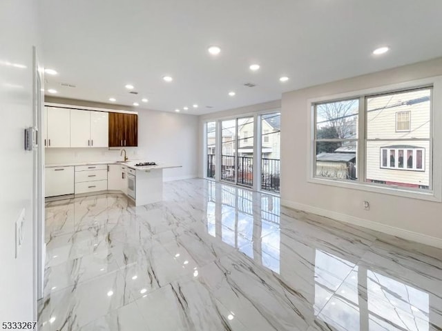 kitchen with oven, sink, white cabinetry, and gas stovetop