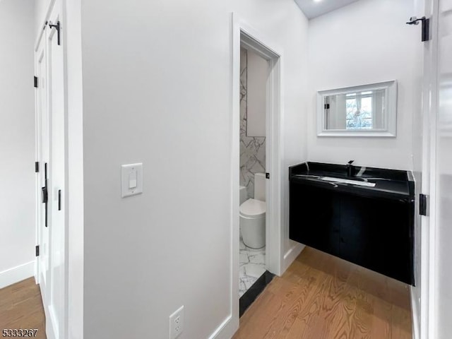 bathroom featuring wood-type flooring, toilet, and vanity