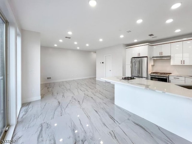 kitchen featuring white cabinetry, stainless steel appliances, and tasteful backsplash