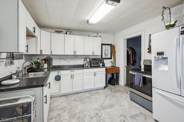 kitchen with sink, tasteful backsplash, stainless steel range with electric stovetop, white fridge with ice dispenser, and white cabinets