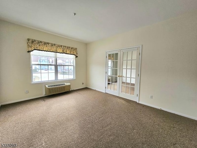 carpeted spare room featuring a wall mounted AC and french doors