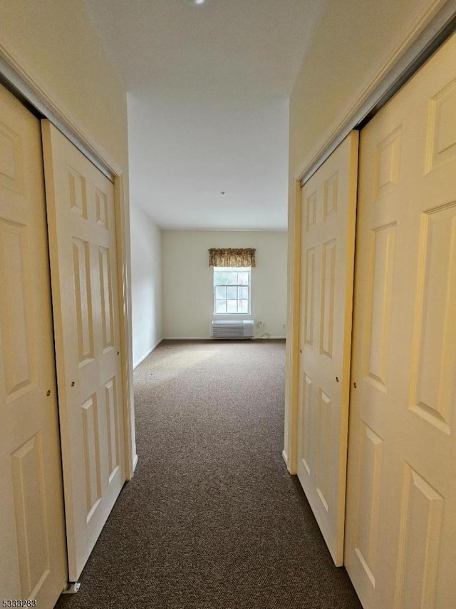 corridor featuring dark colored carpet