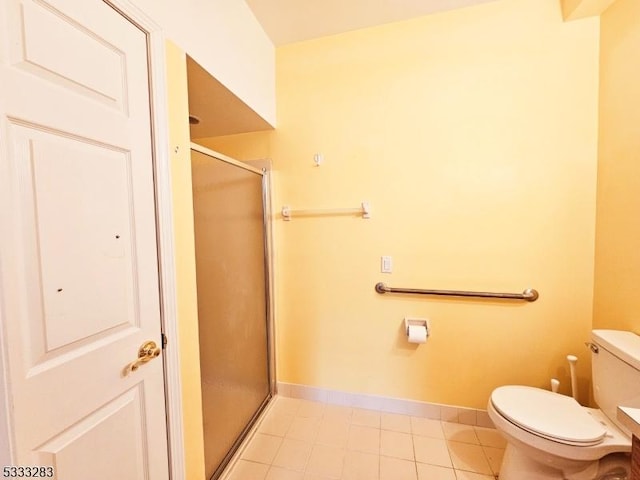 bathroom featuring toilet, tile patterned floors, and a shower with shower door