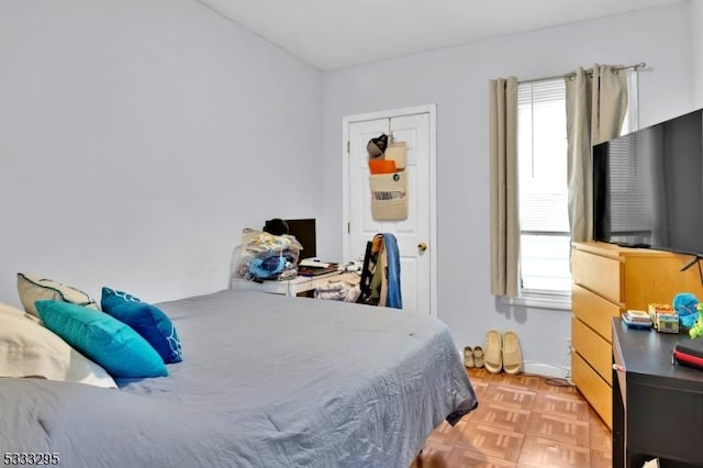 bedroom featuring light parquet floors and multiple windows