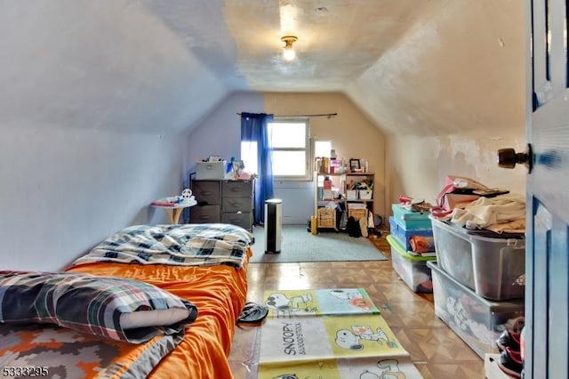 bedroom with light parquet floors and lofted ceiling