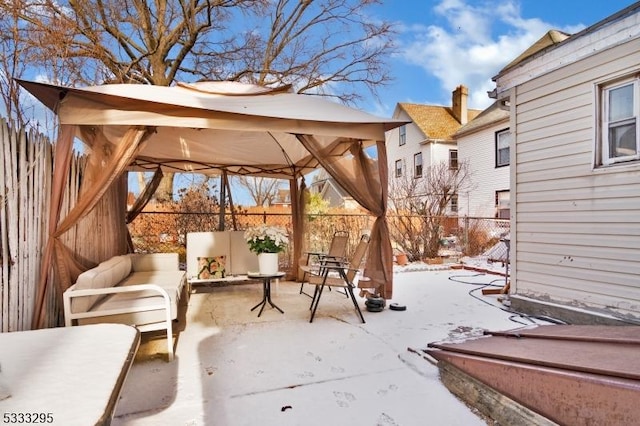 snow covered patio featuring a gazebo and an outdoor living space