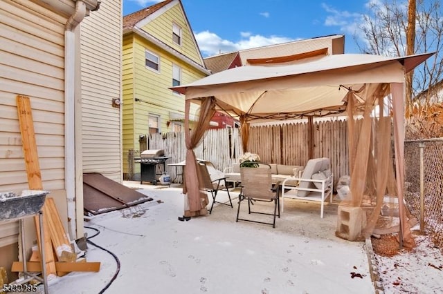 snow covered patio with a grill and a gazebo