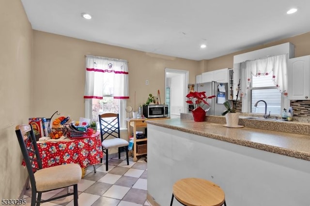 kitchen featuring sink, a wealth of natural light, stainless steel appliances, and white cabinetry