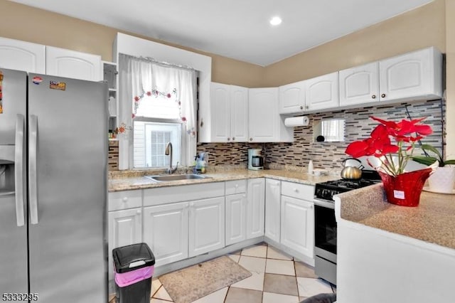 kitchen with stainless steel appliances, white cabinetry, and sink