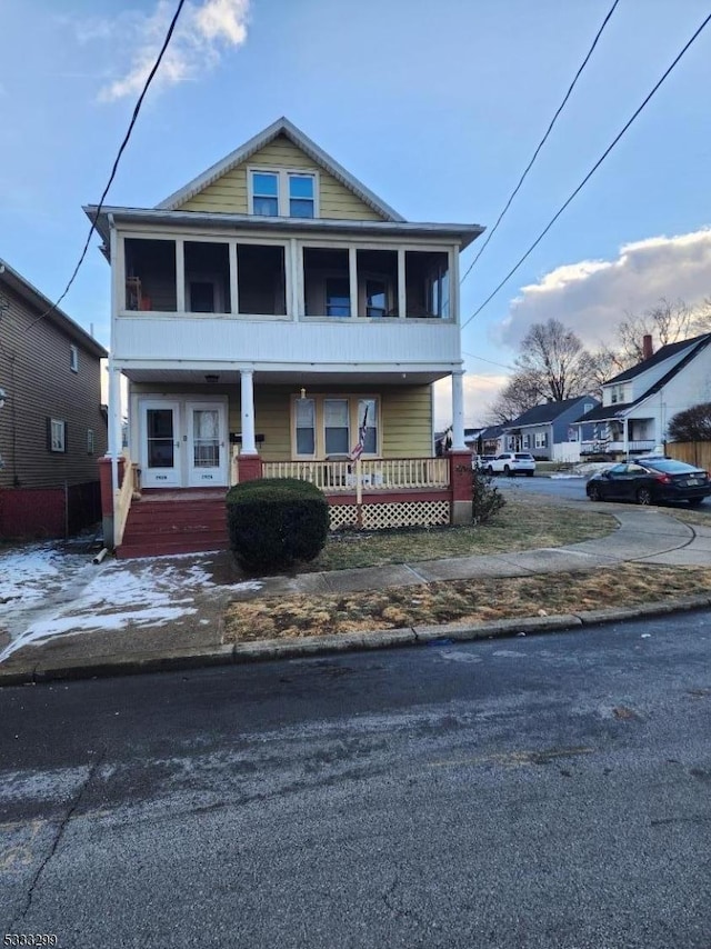 view of front of home with covered porch and a sunroom