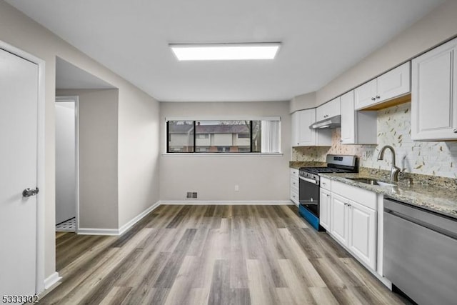 kitchen featuring appliances with stainless steel finishes, sink, white cabinets, and backsplash