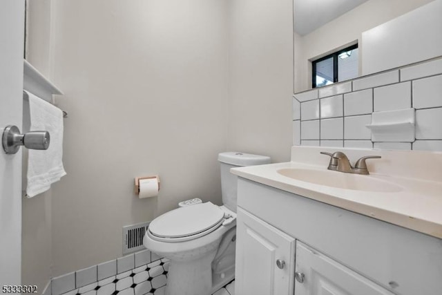 bathroom with vanity, backsplash, and toilet