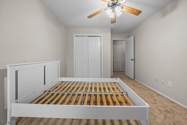 unfurnished bedroom featuring carpet flooring, ceiling fan, and a closet