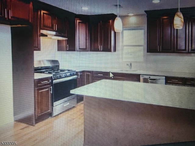 kitchen with sink, hanging light fixtures, stainless steel appliances, and tasteful backsplash