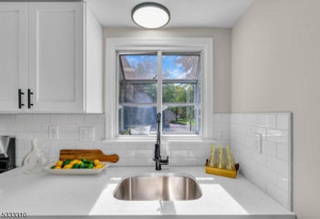 kitchen featuring sink, white cabinetry, and tasteful backsplash