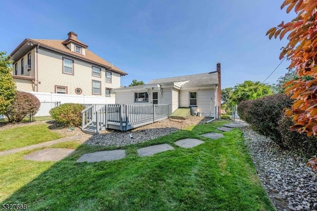 back of house featuring a lawn, a pergola, and a wooden deck