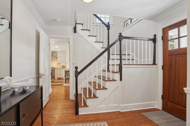 entrance foyer with hardwood / wood-style flooring and ornamental molding