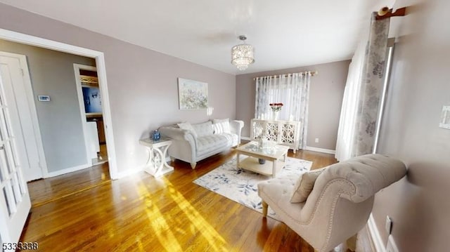 living room featuring an inviting chandelier and dark hardwood / wood-style floors