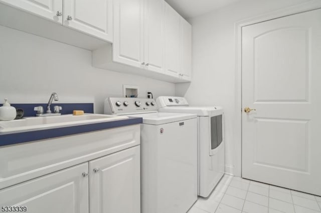 laundry area with light tile patterned flooring, cabinets, sink, and washing machine and dryer