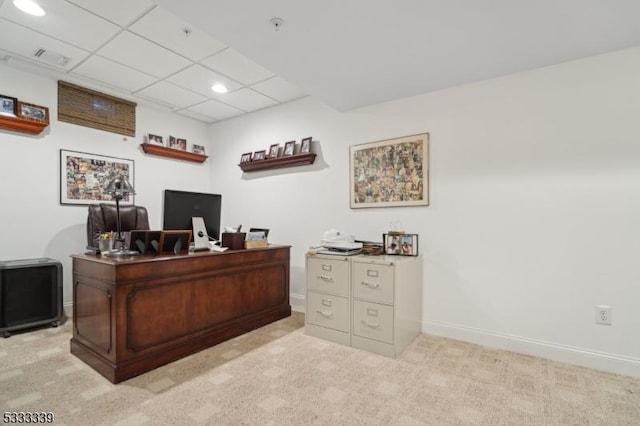 carpeted office with a paneled ceiling