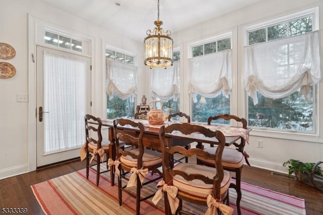 dining room with an inviting chandelier and dark hardwood / wood-style flooring