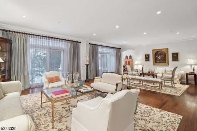 living room with crown molding, dark wood-type flooring, and a wealth of natural light