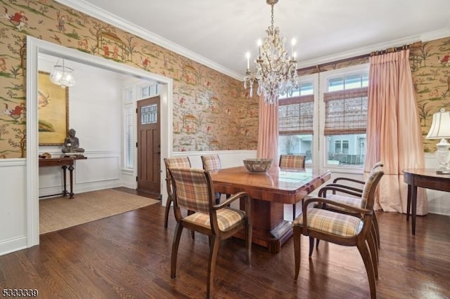 dining space featuring dark wood-type flooring, ornamental molding, and a chandelier