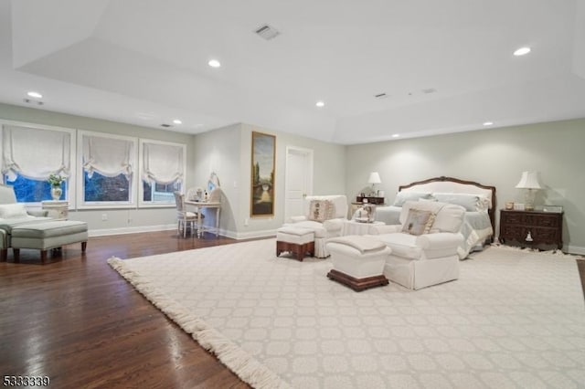 bedroom featuring a raised ceiling and light hardwood / wood-style floors