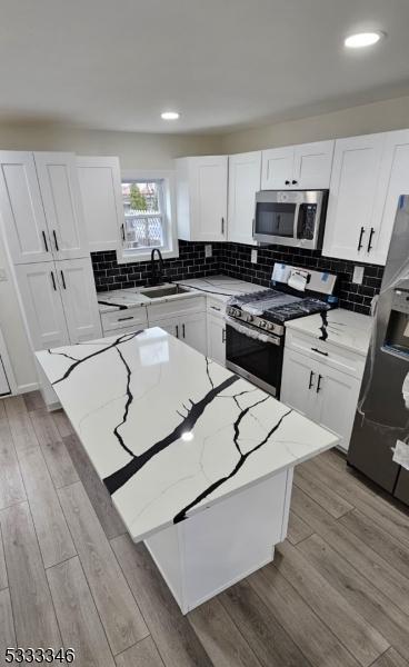 kitchen featuring light stone countertops, stainless steel appliances, and a kitchen island