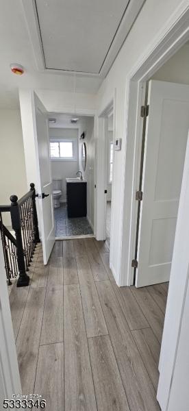 hallway with sink and light wood-type flooring