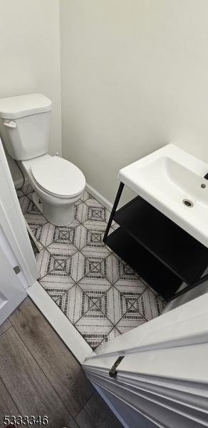 bathroom featuring toilet, hardwood / wood-style flooring, and vanity