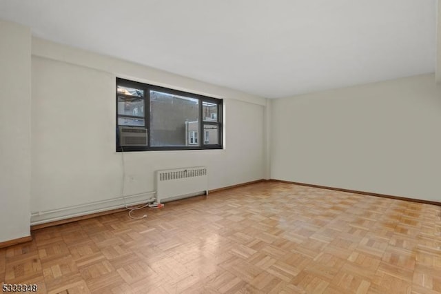 empty room with radiator heating unit and light parquet floors