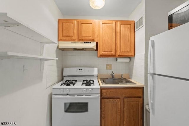 kitchen featuring white appliances, sink, and backsplash