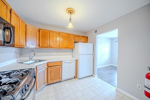 kitchen featuring decorative light fixtures, sink, and white appliances