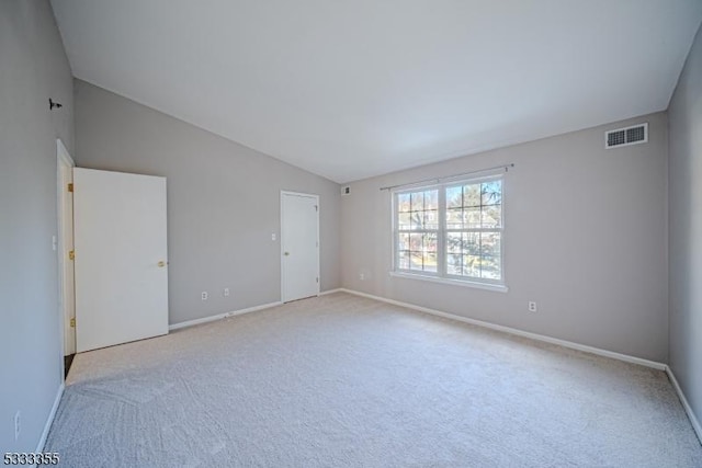 carpeted spare room featuring lofted ceiling