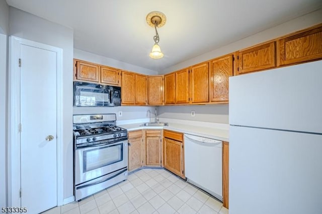 kitchen with sink, white appliances, and pendant lighting