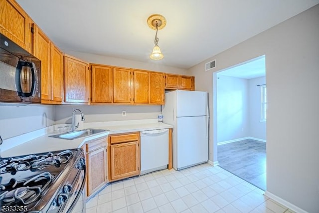 kitchen with hanging light fixtures, sink, and white appliances