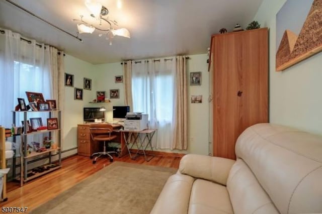 home office featuring hardwood / wood-style flooring and a baseboard heating unit