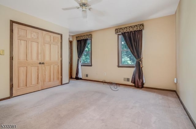 unfurnished bedroom featuring ceiling fan, carpet, and a closet