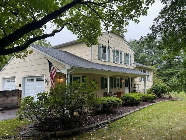 view of side of home featuring covered porch and a garage