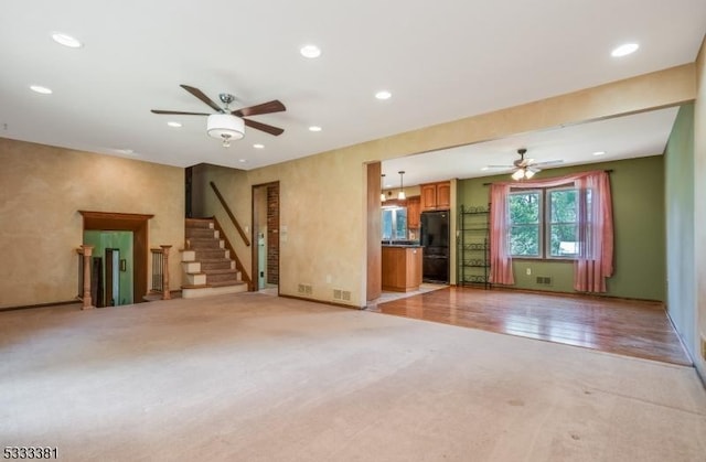 unfurnished living room with ceiling fan and light carpet