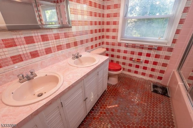 4 Webster Rd, Franklin Twp, NJ 08873 - bathroom featuring toilet, double vanity, wallpapered walls, bath / shower combo with glass door, and tile walls